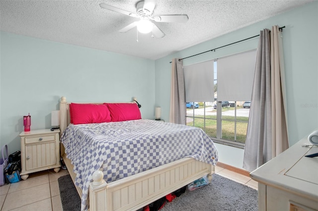 bedroom featuring ceiling fan, a textured ceiling, and light tile patterned flooring