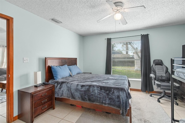 tiled bedroom featuring a textured ceiling and ceiling fan