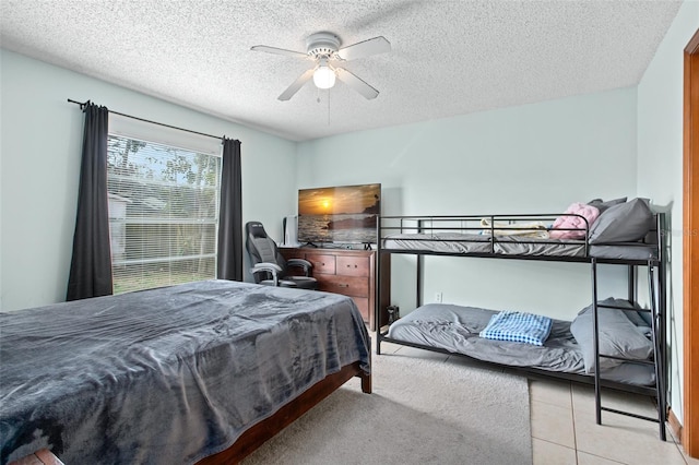 tiled bedroom featuring a textured ceiling and ceiling fan