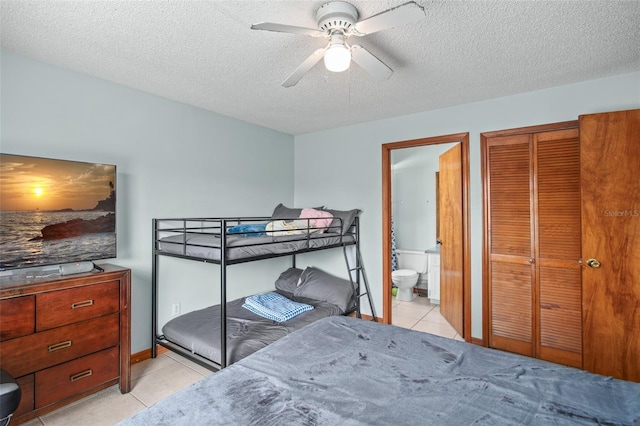 tiled bedroom featuring ceiling fan, connected bathroom, a textured ceiling, and a closet