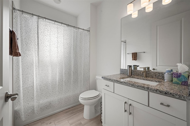 full bathroom with vanity, wood-type flooring, shower / bath combo with shower curtain, and toilet