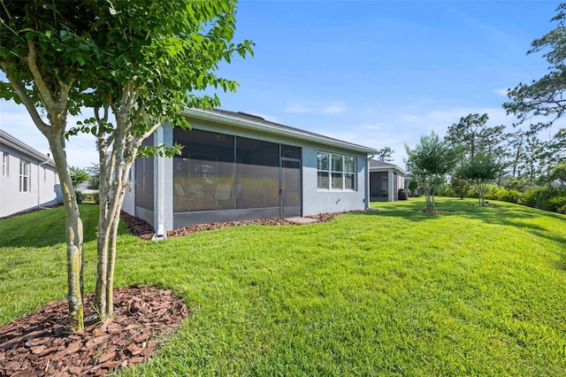 back of house featuring a yard and a sunroom