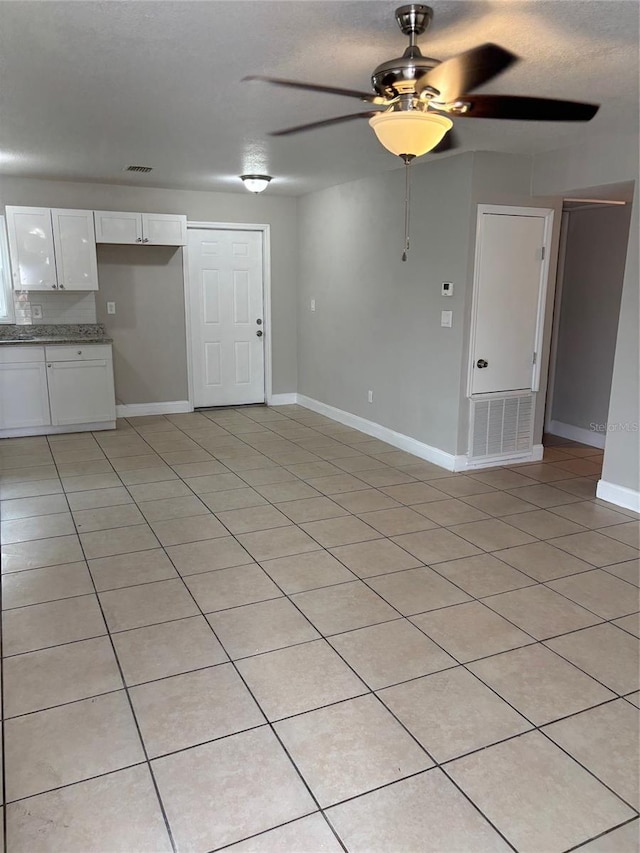 unfurnished living room with light tile patterned flooring and ceiling fan