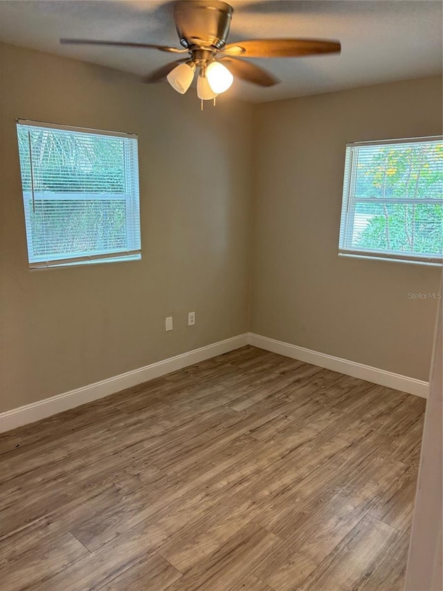 spare room with hardwood / wood-style flooring and ceiling fan