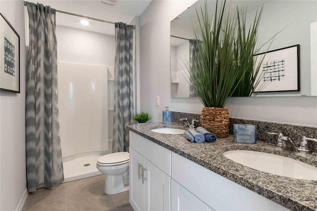 bathroom with tile patterned flooring, vanity, toilet, and walk in shower