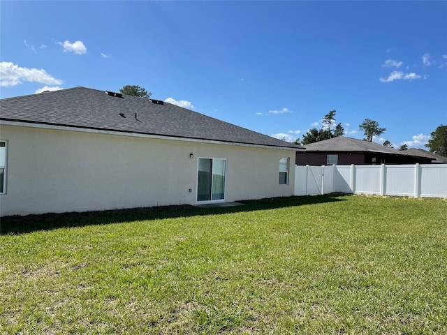 rear view of property featuring a lawn