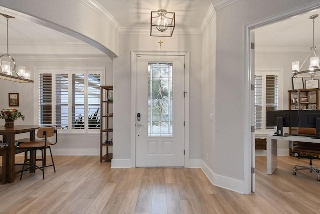 entryway featuring a notable chandelier, crown molding, and light hardwood / wood-style floors