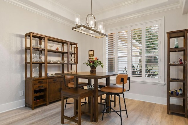 dining area with ornamental molding, a chandelier, and light wood-type flooring