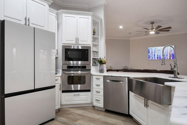 kitchen with white cabinetry, ornamental molding, appliances with stainless steel finishes, and sink