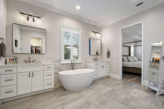 bathroom with crown molding, a washtub, vanity, and tile walls