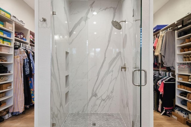 bathroom featuring wood-type flooring and a shower with door