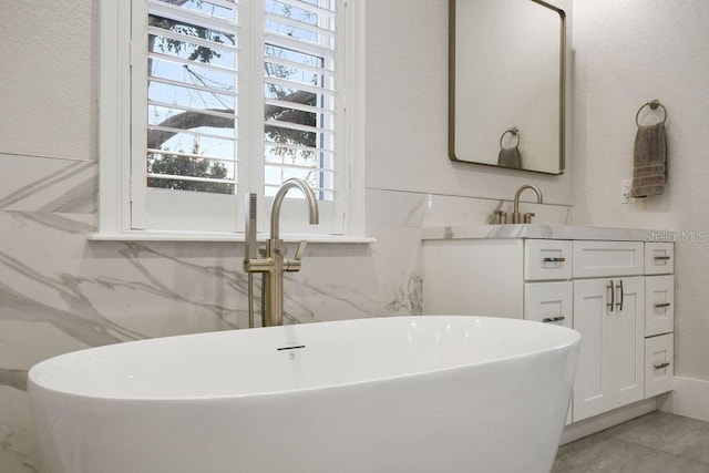 bathroom with a tub to relax in, vanity, and a wealth of natural light