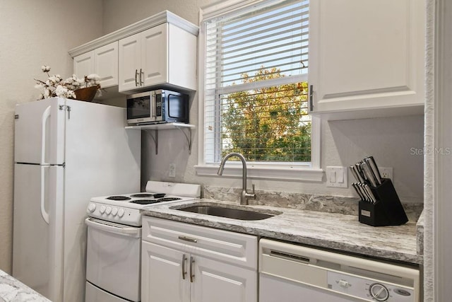 kitchen featuring white cabinetry, sink, white appliances, and light stone counters