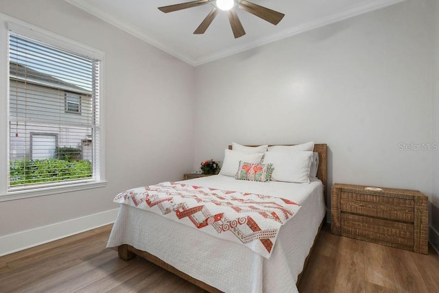 bedroom featuring hardwood / wood-style flooring, ornamental molding, and ceiling fan