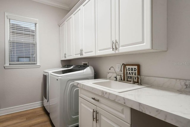 laundry room featuring sink, cabinets, separate washer and dryer, light wood-type flooring, and ornamental molding