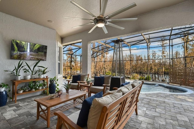 view of patio featuring ceiling fan, an outdoor hangout area, and glass enclosure