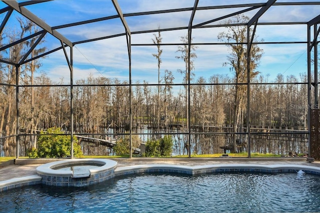 view of pool featuring an in ground hot tub and glass enclosure