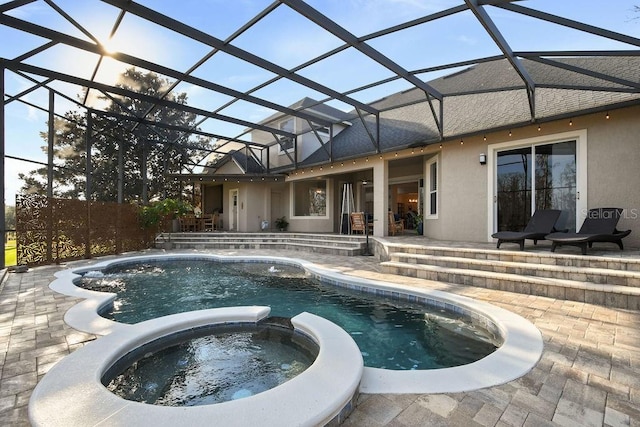 view of pool featuring an in ground hot tub, a patio area, and glass enclosure