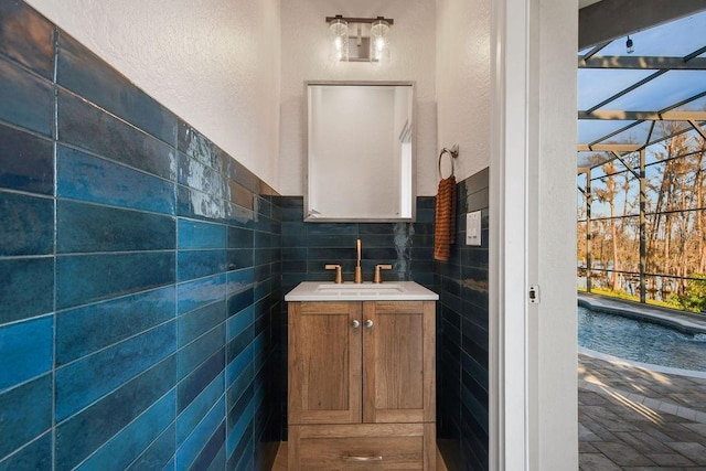 bathroom featuring vanity and tile walls