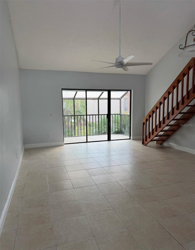 tiled empty room featuring a textured ceiling and ceiling fan