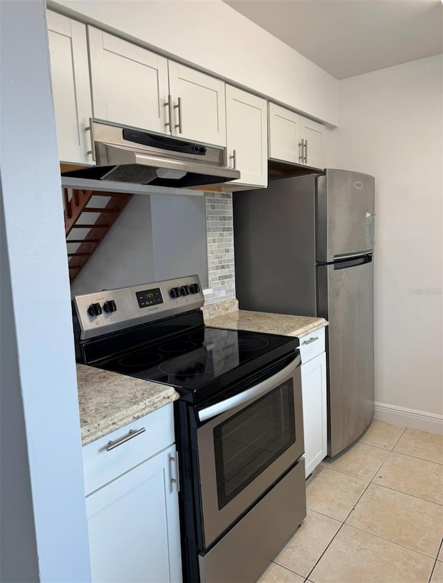 kitchen featuring tasteful backsplash, white cabinets, light tile patterned floors, light stone counters, and stainless steel appliances