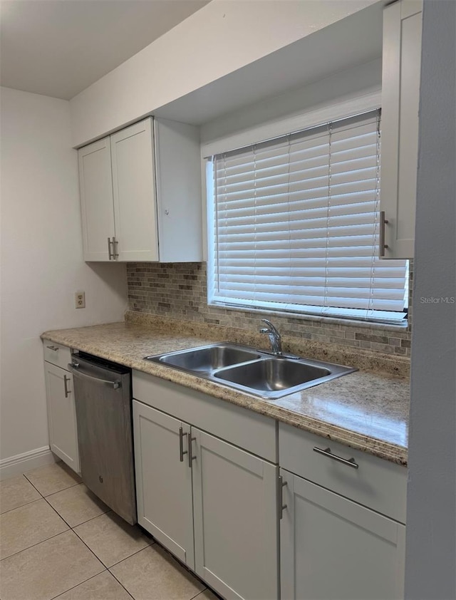 kitchen with stainless steel dishwasher, light tile patterned floors, sink, and backsplash