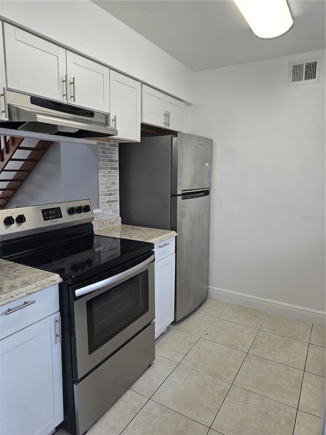 4826 Marks Ter Unit 389, Orlando, FL 32811 - kitchen with appliances with stainless steel finishes, under cabinet range hood, white cabinetry, light tile patterned floors, and light stone counters