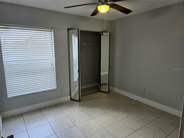 4826 Marks Ter Unit 389, Orlando, FL 32811 - unfurnished bedroom with light tile patterned flooring, a ceiling fan, a closet, and multiple windows
