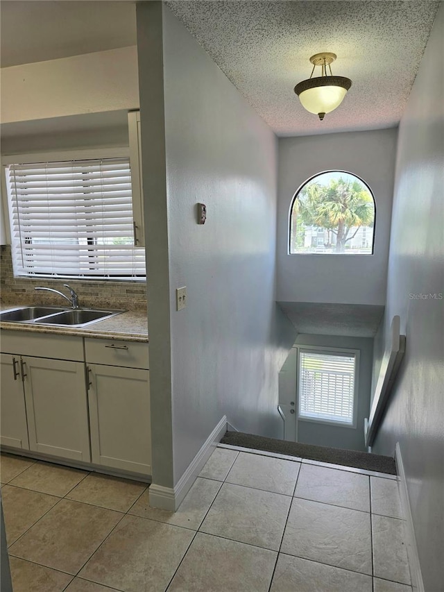 4826 Marks Ter Unit 389, Orlando, FL 32811 - doorway featuring light tile patterned flooring, a textured ceiling, and plenty of natural light