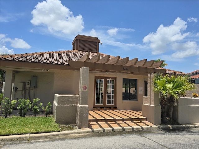 4826 Marks Ter Unit 389, Orlando, FL 32811 - doorway to property featuring a tiled roof, stucco siding, and french doors