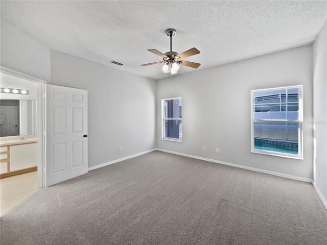 carpeted spare room featuring sink, a textured ceiling, and ceiling fan