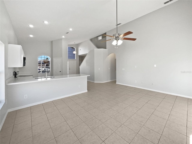 unfurnished living room featuring ceiling fan and sink