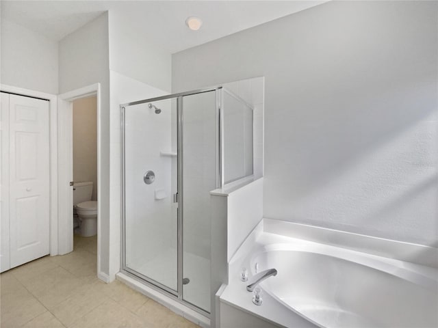 bathroom with tile patterned floors, independent shower and bath, and toilet