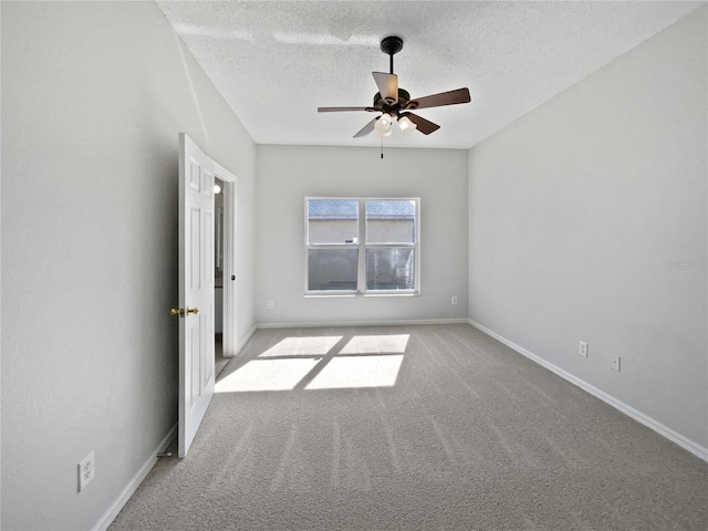 carpeted empty room with ceiling fan and a textured ceiling