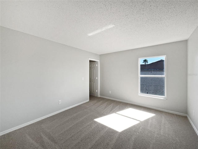 carpeted spare room featuring a textured ceiling