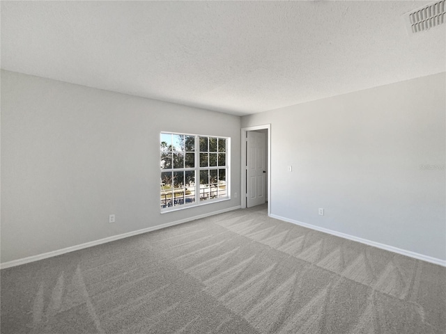 carpeted empty room with a textured ceiling