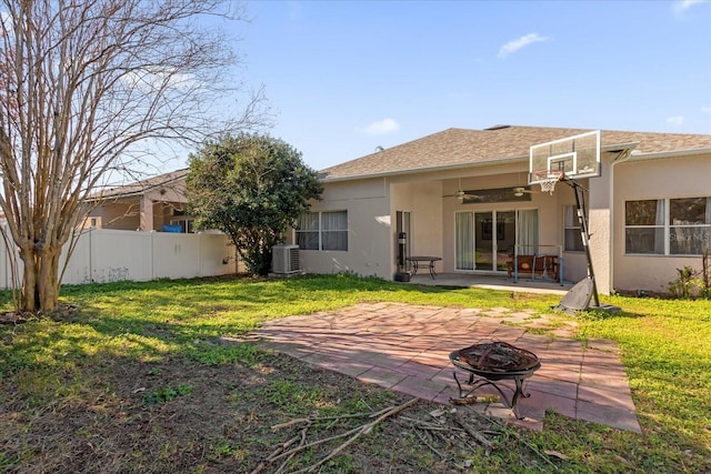 rear view of house with a yard, a patio area, a fire pit, and central air condition unit