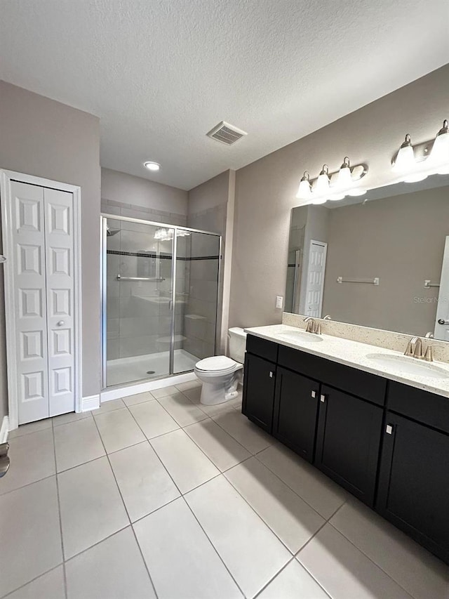 bathroom with tile patterned floors, vanity, toilet, and a textured ceiling