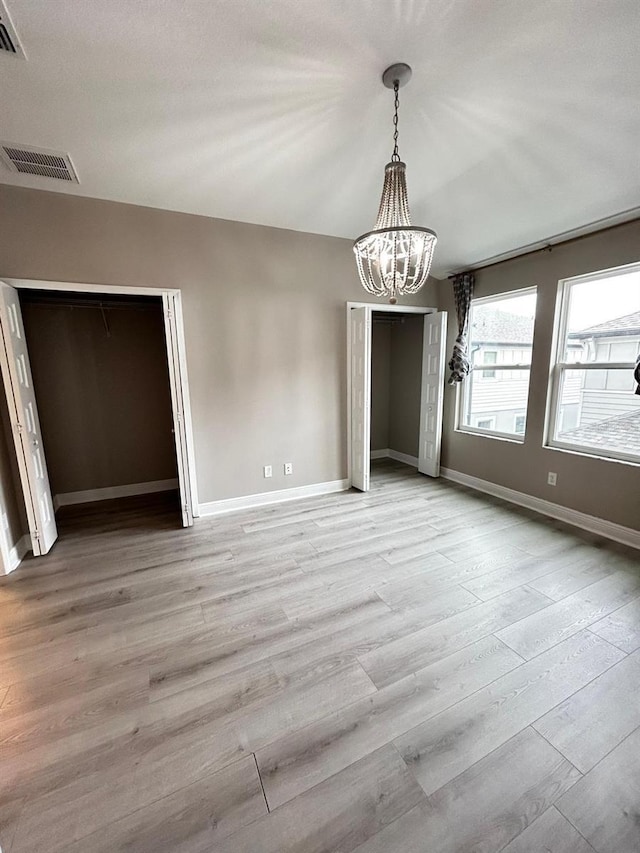 unfurnished dining area with light hardwood / wood-style flooring and a chandelier