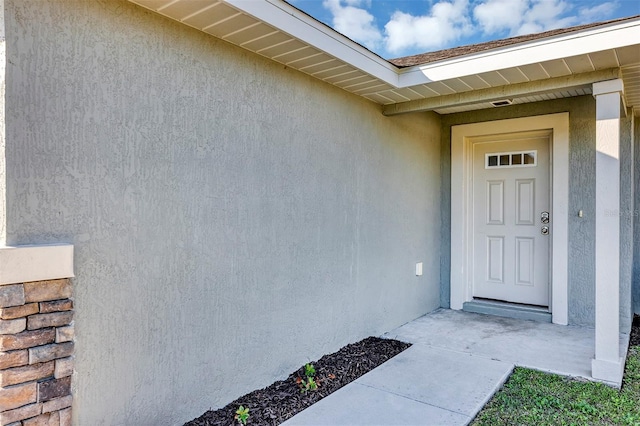 doorway to property featuring stucco siding