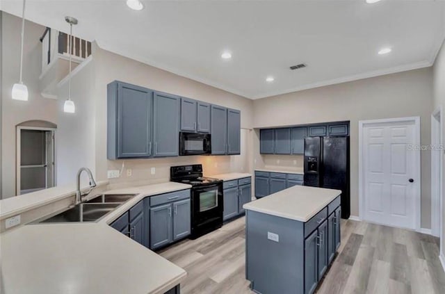 kitchen featuring sink, hanging light fixtures, a center island, black appliances, and light hardwood / wood-style flooring