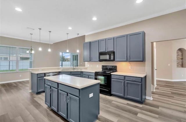 kitchen featuring sink, a center island, ornamental molding, pendant lighting, and black appliances