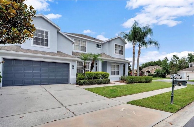 traditional-style house featuring a garage, stucco siding, driveway, and a front yard