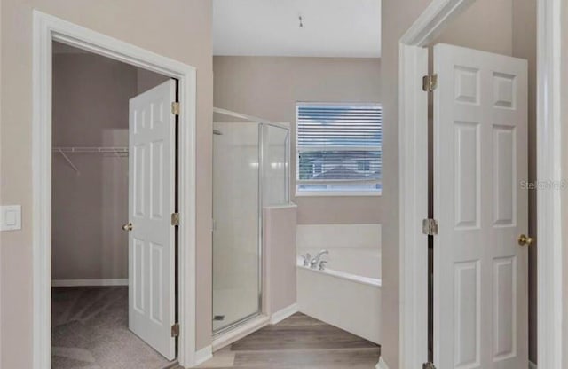 bathroom featuring hardwood / wood-style flooring and independent shower and bath