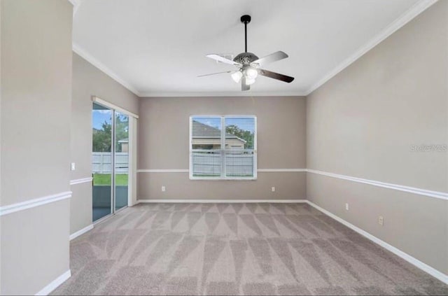 carpeted spare room featuring crown molding and ceiling fan