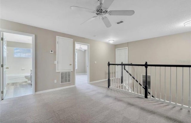 carpeted spare room with ceiling fan