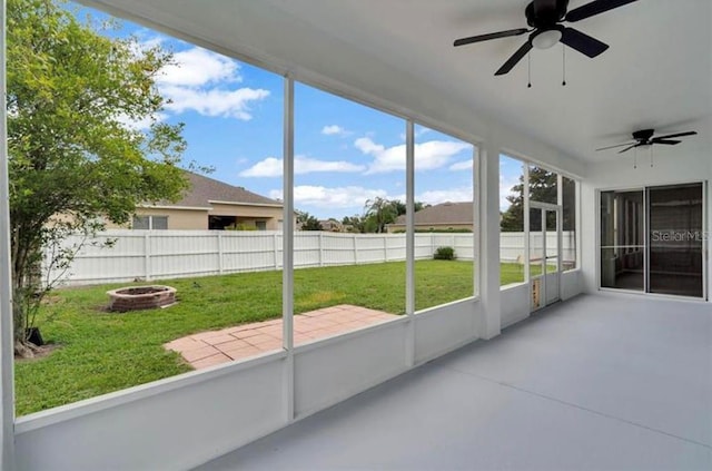 unfurnished sunroom featuring ceiling fan