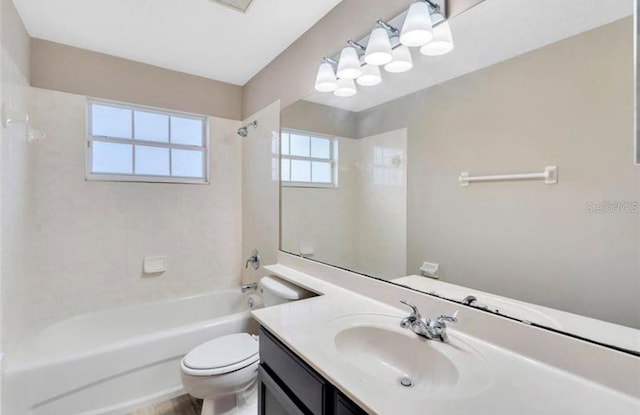 full bathroom featuring vanity, tiled shower / bath, and toilet