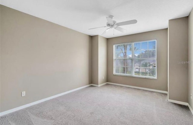 empty room featuring light colored carpet and ceiling fan