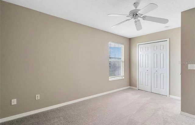 unfurnished bedroom with light carpet, ceiling fan, and a closet